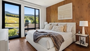 Relax in this serene bedroom with a large bed and a stunning view of the surrounding landscape.