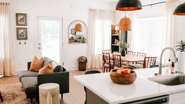 Una cocina moderna con comedor, sofá y una pequeña mesita auxiliar.