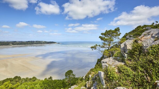 A coastal landscape with a clear sky, a sandy beach, and rocky terrain with vegetation. - Ti Kaouenn - PLOUARET (PLOUARET)