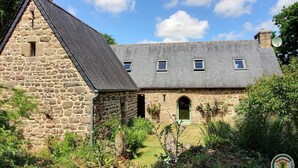 A stone building with a sloped roof, a central entrance, and small windows. - Ti Kaouenn - PLOUARET (PLOUARET)