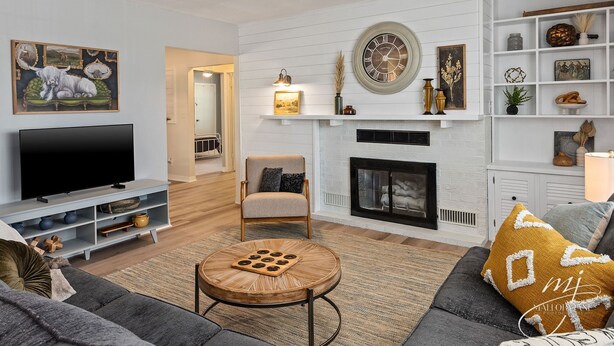 A living room with a TV, sofa, round coffee table, fireplace, and various decorations.
