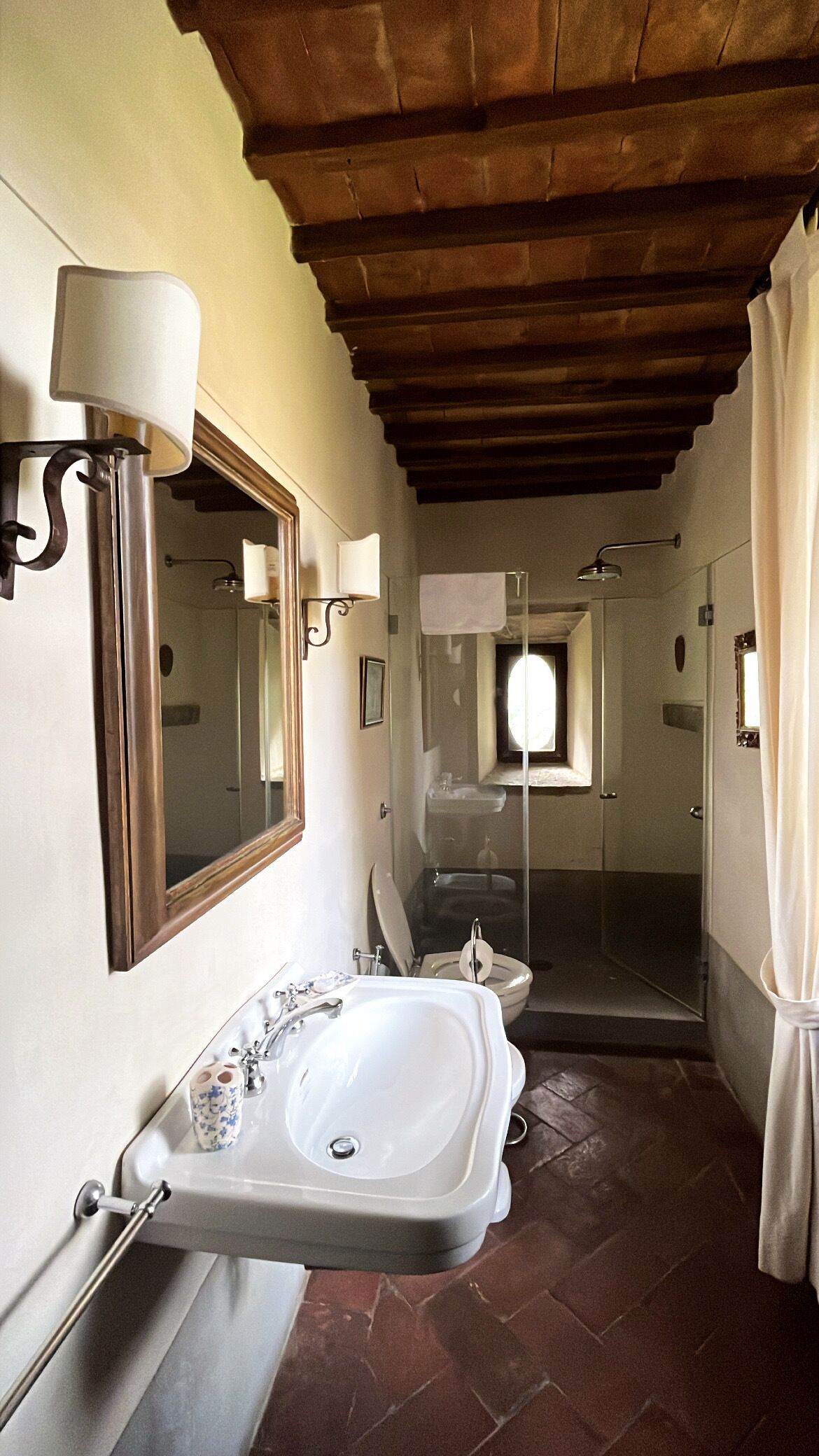 Une salle de bain avec un lavabo, un miroir et une douche.