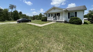 A single-story house with a front porch, a driveway, and a lawn. - Relaxing 2 bedroom home minutes away from PMRP (Beattyville)
