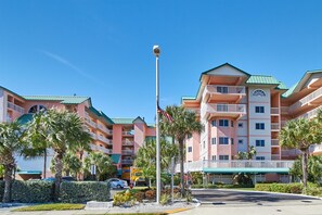 Un hôtel à plusieurs étages doté de balcons, d’un toit végétalisé et surplombant un ciel d’un bleu limpide.