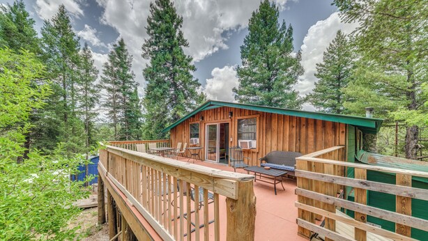 A wooden cabin with a deck, surrounded by tall trees and a clear sky. - Cozy Mountaintop Retreat < 6 Mi to Ski Cloudcroft! (Cloudcroft)