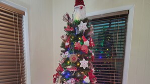 Un árbol de Navidad adornado con adornos y una figura de Papá Noel.