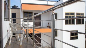 A modern building with a metal staircase and a chair. - Executive 3-bed Furnished Apartment in Kwashieman (Accra)