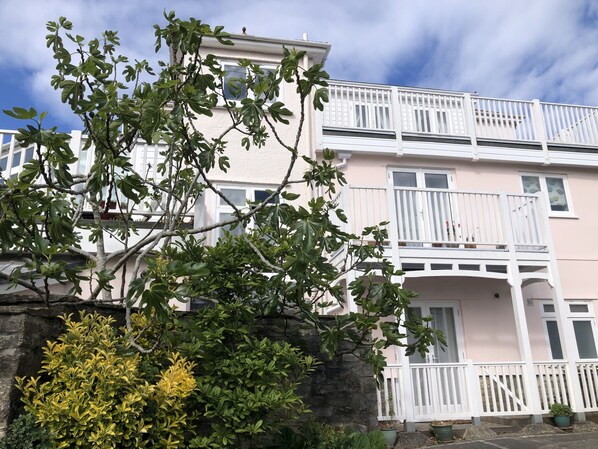 Un immeuble à plusieurs étages, doté de balcons et d’un mur en pierre.