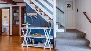 A staircase with a wooden handrail and a blue wall with a nautical-themed decoration.