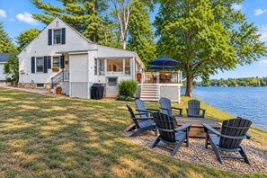 A lakeside cabin with a deck, outdoor seating, and a view of the water. - Luxury Lakefront Retreat - Private Beach, Dock & Cozy She Shed (Sandown)