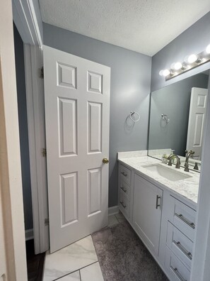 Tina con regadera, secadora de cabello, toallas, papel de baño 