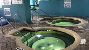 Indoor swimming pools with safety signs, a tiled floor, and a blue wall.