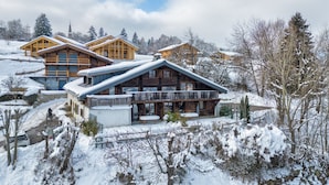 A chalet-style building with a large balcony and a covered patio area.