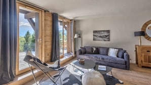 Un salon moderne avec une grande fenêtre, un canapé, une table basse et une lampe.