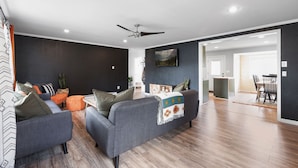 A modern living room with grey sofas, a ceiling fan, and a wooden floor. - The Aztec Casita - Gateway to incredible memories (Forks)