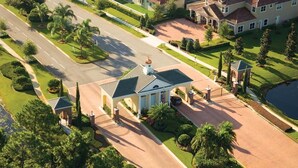 An aerial view of a large estate with a central building, multiple driveways, and well-maintained lawns. - Providence Golf & Country Club Pool Home in Gated & Guarded Community (Davenport)
