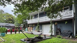 A two-story building with a balcony, a hammock, and a barbecue area. - Hidden Gem 10 mins to Downtown or Wrightsville Beach. Brand New King Sized Bed (Wilmington)