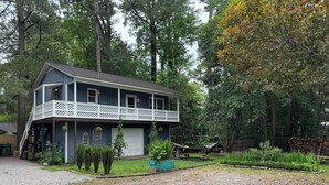 A two-story house with a balcony, a garage, and a well-maintained garden. - Hidden Gem 10 mins to Downtown or Wrightsville Beach. Brand New King Sized Bed (Wilmington)