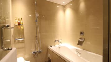A modern bathroom with a bathtub, shower, and toilet.