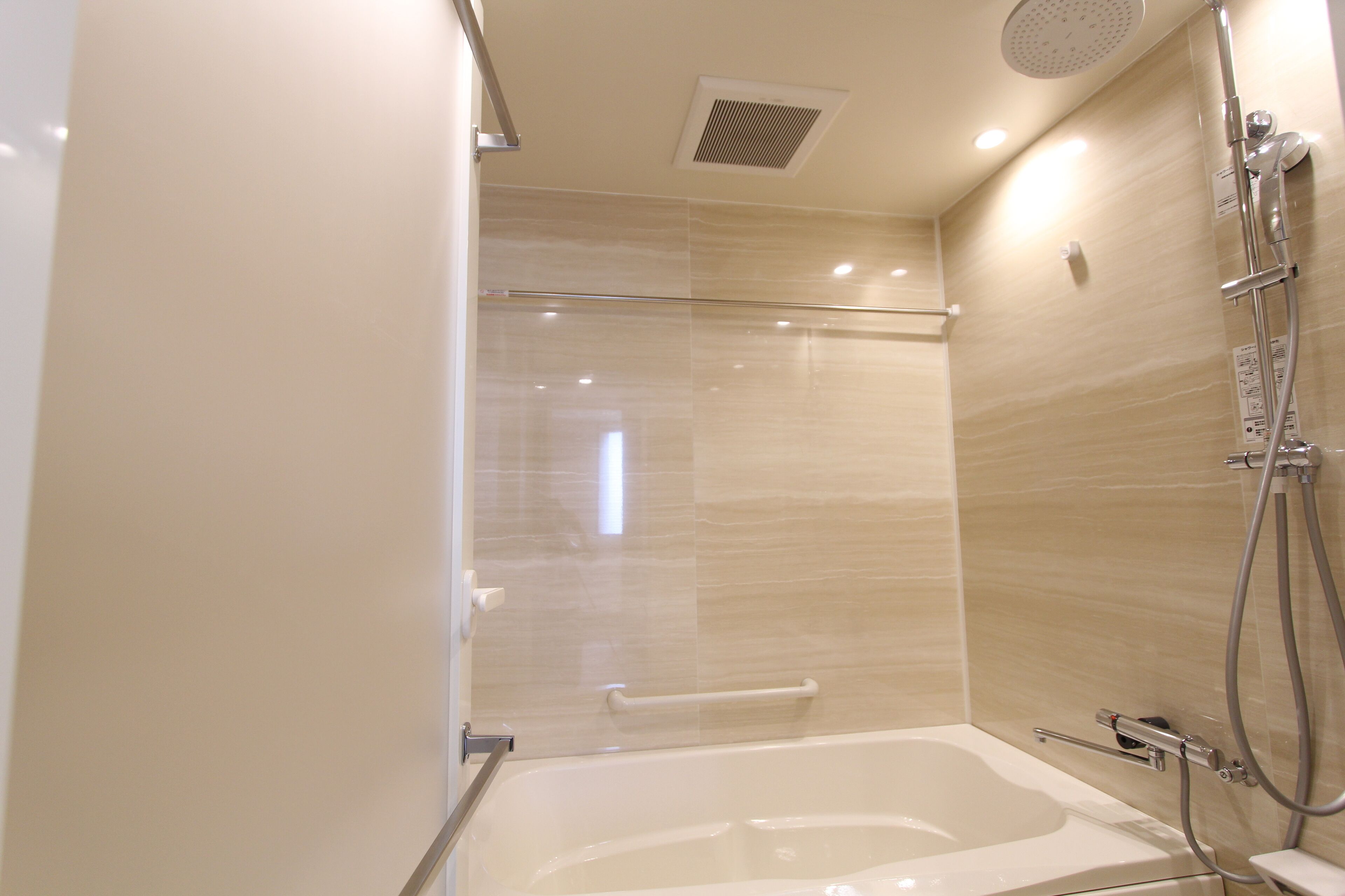 Een moderne badkamer met een glazen douchecabine, een badkuip en een handdouche.