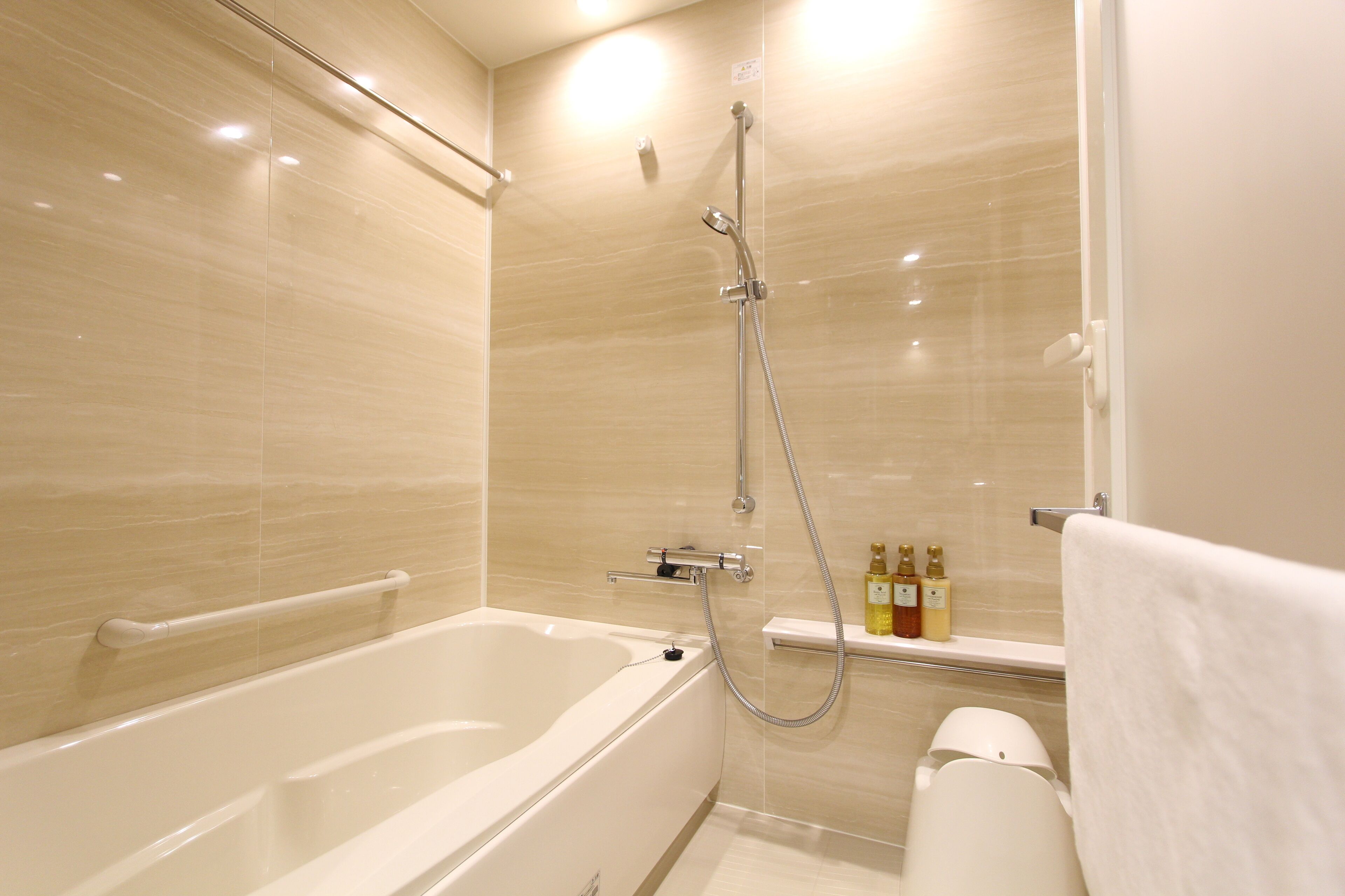 A modern bathroom with a bathtub, shower, and toilet.