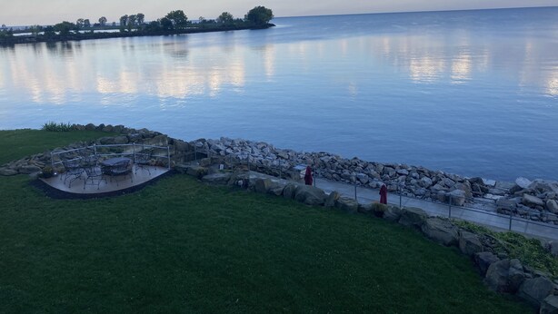 Eine Terrassenausrichtung am Seeufer mit Gartenmöbeln und Blick auf das Wasser.