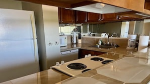 A modern kitchen with a stainless steel refrigerator, double electric range, and a large island with a sink. - Best View in Hilo - Pool, WIFI, 2 BD Condo (Hilo)
