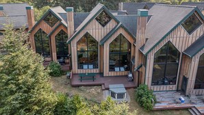 A row of wooden cabins with large windows and a deck area in front.