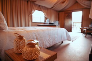 A bedroom with a large bed, wooden nightstands, and two woven lanterns. - Indomito Resort & Hotel Boutique (Valle de Guadalupe)