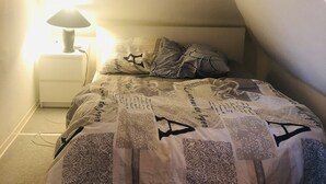 Ein Schlafzimmer mit einem Bett, einem Nachttisch und einer Lampe.