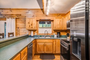 Enjoy cooking in this well-equipped kitchen with a stainless steel refrigerator, oven, and ample cabinetry.