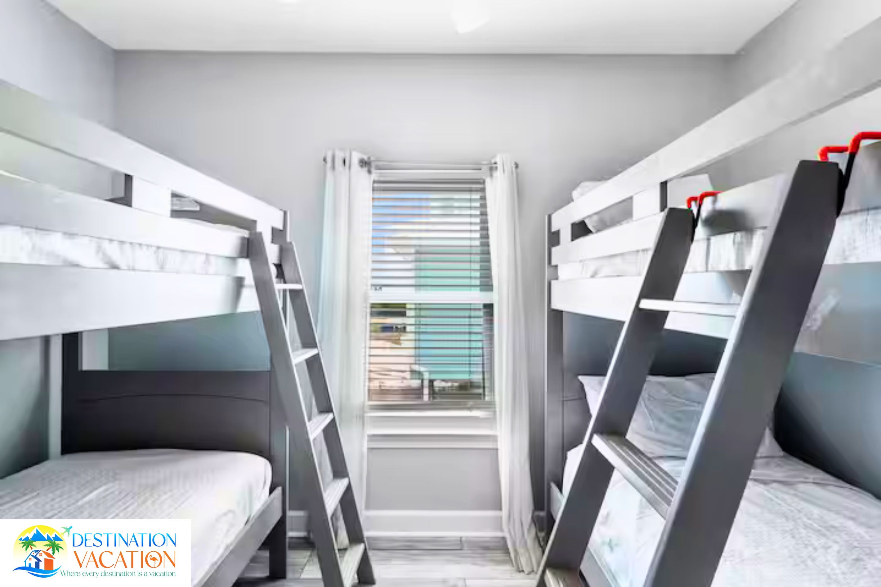 Ein Zimmer mit Etagenbetten, einem Fenster mit Jalousien und einer Treppe.