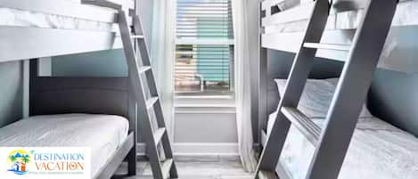 Una habitación con literas, una ventana con persianas y una escalera.