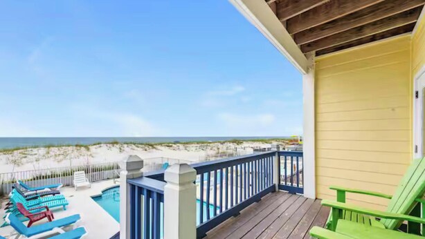 A wooden deck with a pool and beach chairs, overlooking a sandy beach and ocean. - Oceanfront Escape: 5BR Beach House w/ Pool for 12 (Gulf Shores)