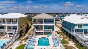Un hôtel en bord de mer doté d’une piscine, de plusieurs balcons et d’une jetée.