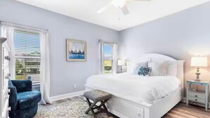 A bedroom with a bed, a chair, a nightstand, and a ceiling fan. - Oceanfront Escape: 5BR Beach House w/ Pool for 12 (Gulf Shores)