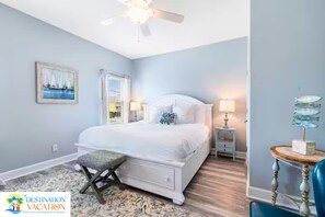 A bedroom with a bed, bedside tables, a ceiling fan, a window with blinds, and a rug. - Gulf Shores Paradise: Beachfront 5BR + Pool + Views (Gulf Shores)