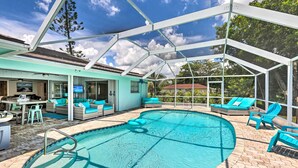 A covered outdoor swimming pool with lounge chairs and a dining area. - Bright & Breezy Cape Coral Retreat w/ Pool! (Cape Coral)