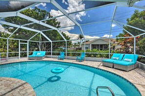 Une piscine couverte dotée de chaises longues et d’une structure servant de parasol.