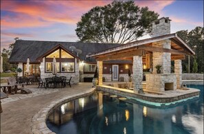 A modern house with a stone exterior, a swimming pool, and outdoor seating. - Ranch Style Paradise * Resort Style Pool * (Tomball)