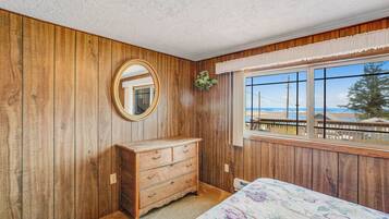 Enjoy a tranquil retreat with a traditional design, featuring a large window offering a view of the beach and ocean.