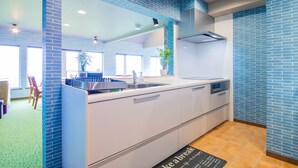 Una cocina moderna con paredes de azulejos azules, un lavamanos de acero inoxidable y un horno empotrado.