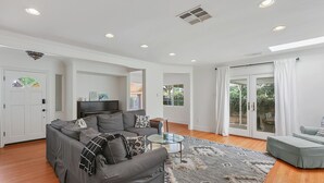 A spacious living room with a sectional sofa, a glass coffee table, and a patterned rug. - Stylish San Fernando Stay with Designer Kitchen Upgrade (San Fernando)