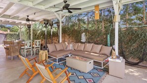An outdoor patio with a sectional sofa, dining chairs, a small table, and a ceiling fan. - Stylish San Fernando Stay with Designer Kitchen Upgrade (San Fernando)