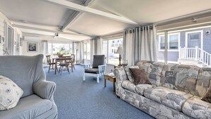 Ein geräumiges Wohnzimmer mit Sofa, Sessel und Essbereich.