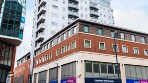A multi-story building with a glass facade and a brick base. - Modern Studio Apt in the heart of Leeds Centre (Leeds)