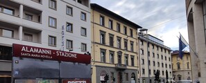 Un hôtel appelé « Alamanni - Stazione Santa Maria Novella », doté d’une façade moderne, de plusieurs étages et d’une entrée imposante.