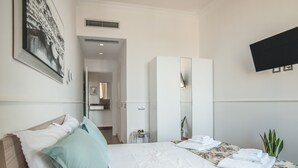 A hotel room with a bed, a wardrobe, a mirror, a TV, and a plant. - Your Home in Florence next to the central train station (Firenze)