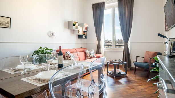 A modern living room with a dining area, a sofa, a coffee table, and a TV. - Your Home in Florence next to the central train station (Firenze)