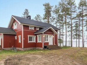 A two-story red house with a front porch and a bicycle parked outside.